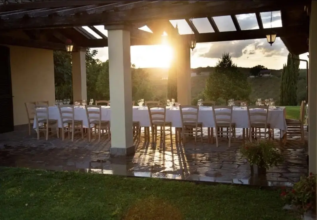 Il porticato apparecchiato con tavoli lunghi al tramonto