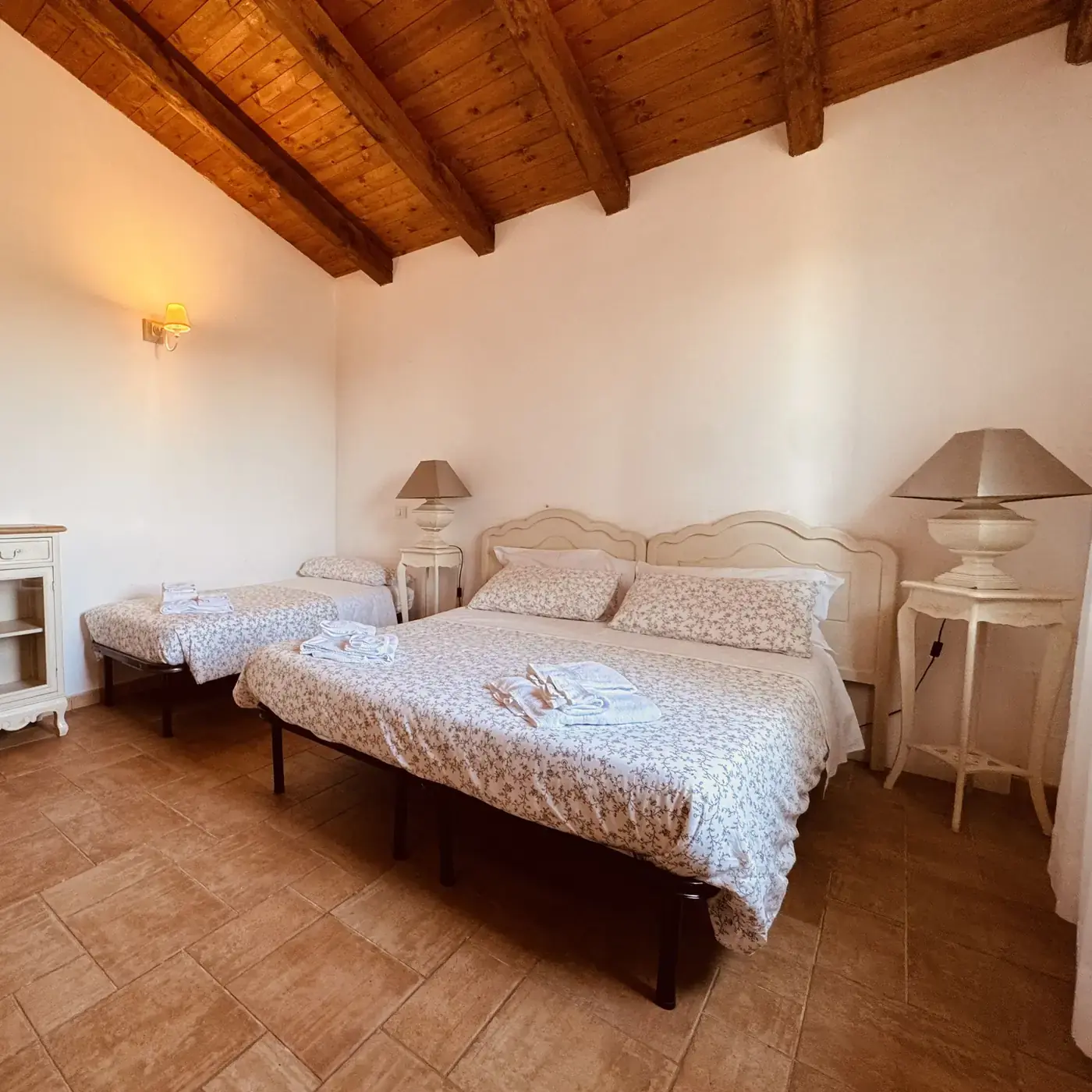 Camera per famiglie con travi in legno, letto matrimoniale e letto singolo