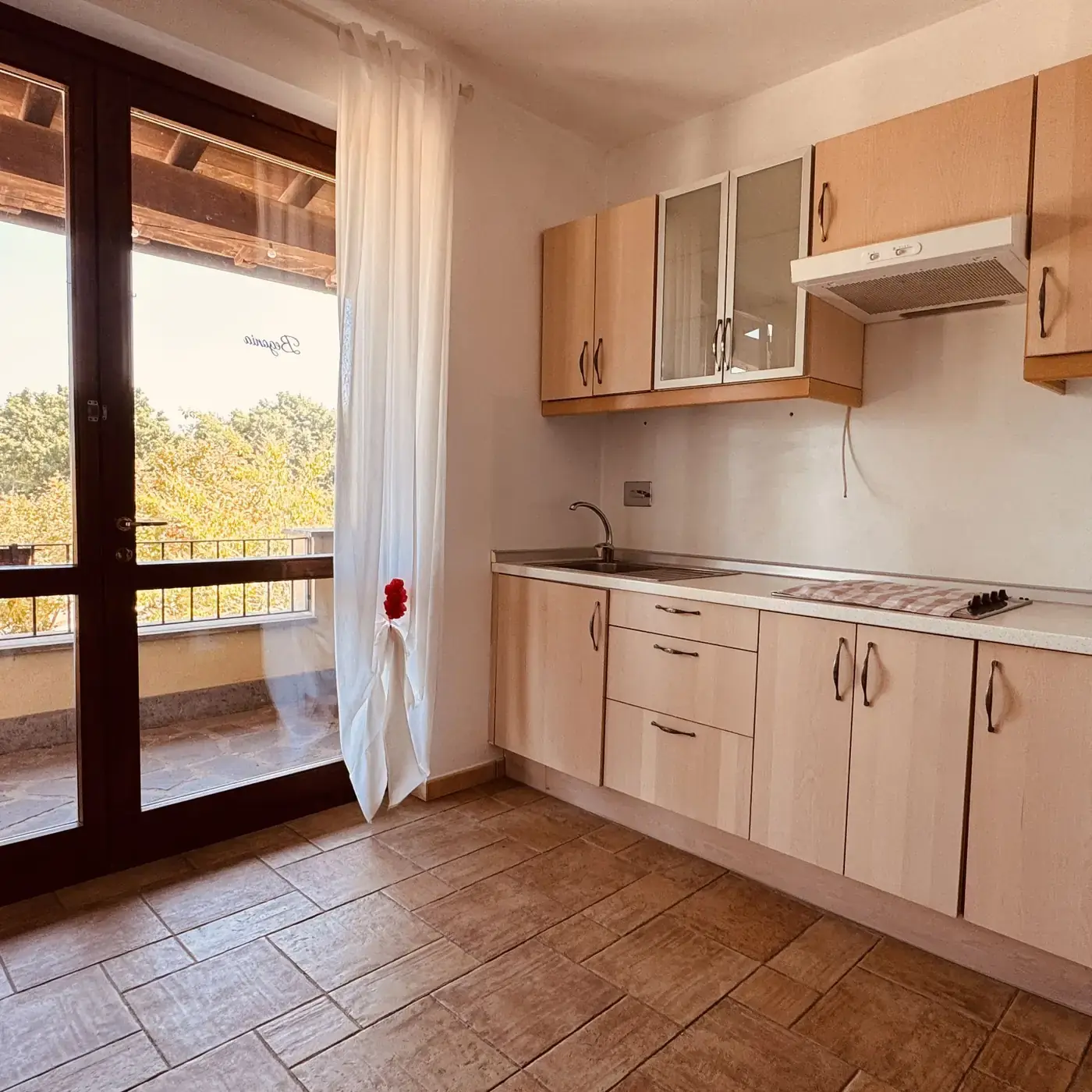 Cucina a disposizione degli ospiti con portafinestra sul verde